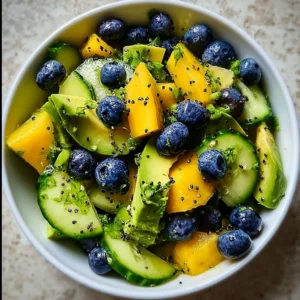 Juicy mango cucumber salad with blueberries and avocado in a bowl